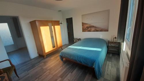 a bedroom with a blue bed and a window at Gites Nature & Espace - Le puits des souhaits in Villedieu-les-Poêles