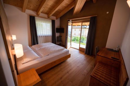 a bedroom with a large bed and a large window at Garnì Tuttotondo in Levico Terme