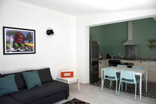 uma sala de estar com um sofá, uma mesa e uma cozinha em House of Love Portimão em Portimão