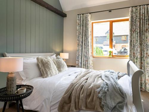 sypialnia z białym łóżkiem i oknem w obiekcie Lantern Lodge w mieście Bramley