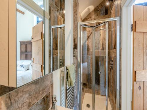 a bathroom with a shower with a glass door at The Victorian Stables in Kimpton