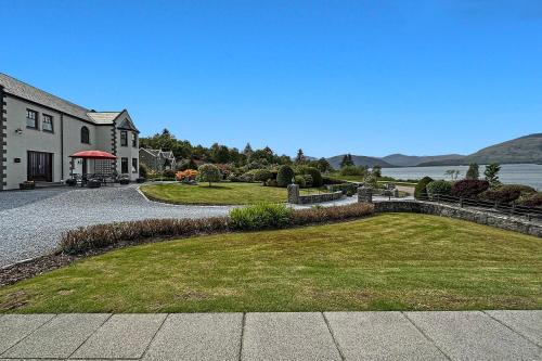 a house with a large yard next to the water at Skyfall Glencoe at Creag an-t Sionnaich in Glencoe