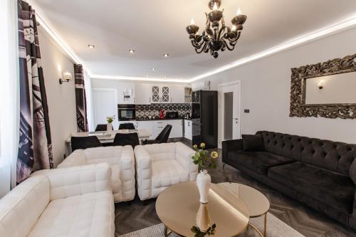 a living room with white couches and a table at Апартаменти Стефани in Plovdiv