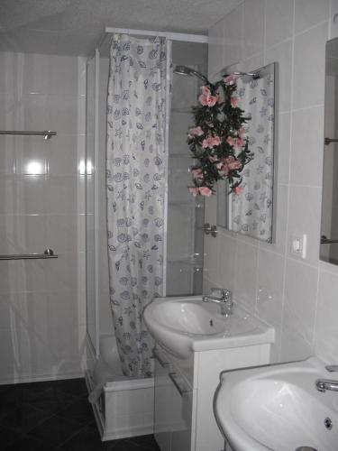 a white bathroom with a sink and a shower at Ferienhaus Angret Winkel in Meißendorf