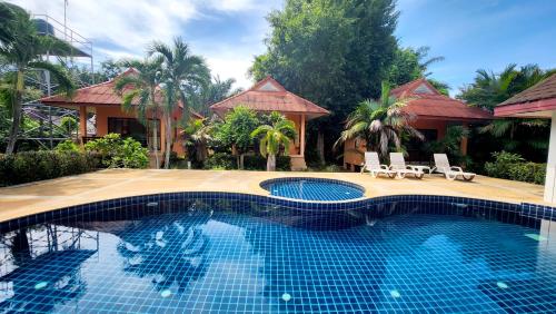 a swimming pool in front of a house at Sawaddee Aonang Resort in Ao Nang Beach