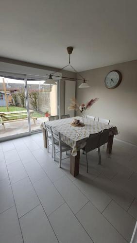 une salle à manger avec une table et une horloge au mur dans l'établissement Maison La Côte, à Boulogne-sur-Mer