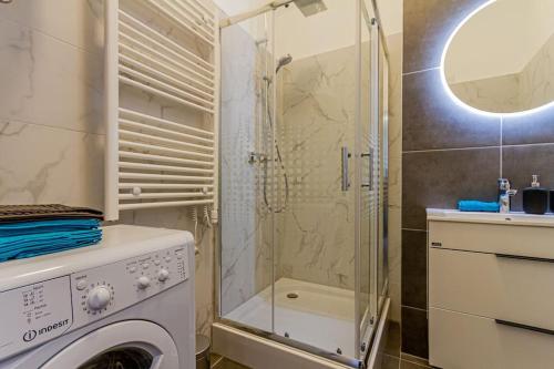 La salle de bains est pourvue d'un lave-linge et d'une douche. dans l'établissement BluebellHome-Castle District, à Budapest