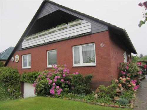 uma casa de tijolos vermelhos com flores em frente em Ferienwohnung Freitag em Winsen