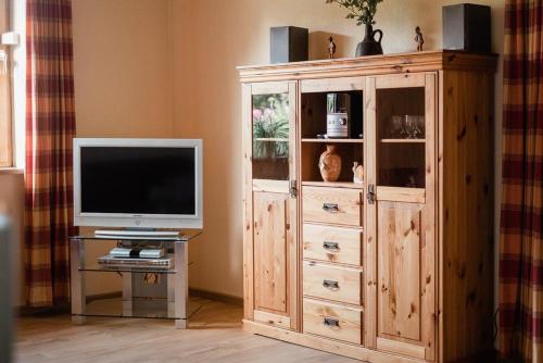 a large wooden entertainment center with a television in a living room at Sonnenschein, Ferienwohnung in Jesteburg