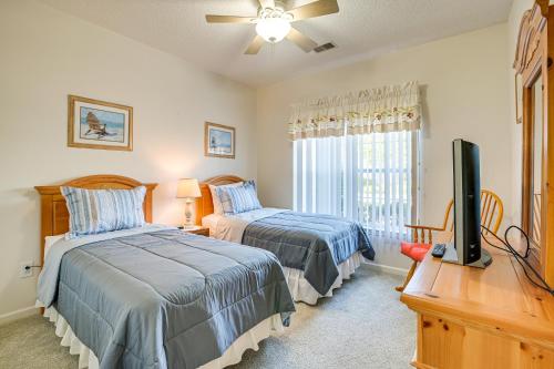 1 Schlafzimmer mit 2 Betten, einem TV und einem Schreibtisch in der Unterkunft Myrtle Beach Condo Golf Courses and Pool Access! in Myrtle Beach