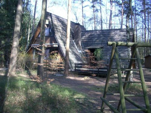 a log cabin in the woods with a fence at Ferienhaus Angret Winkel in Meißendorf