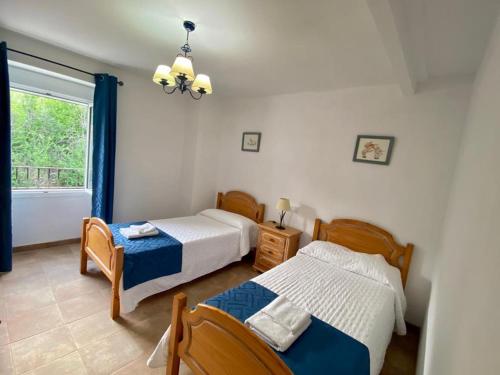 1 dormitorio con 2 camas y ventana en Casilla Soleá, en Carcabuey