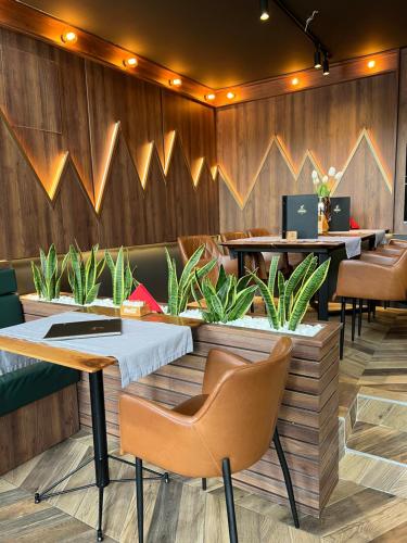 a restaurant with tables and chairs and plants at Modern Mountain La Stella in Kolašin