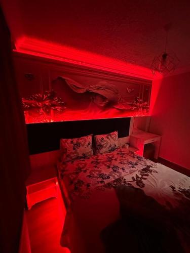 Un dormitorio con una cama con luces rojas. en YAKAMOZ 27 SUİT APART en Bursa