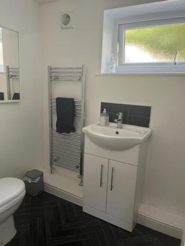 a white bathroom with a sink and a toilet at North Cottage Marlfields Hall, Stunning Location in Adlington