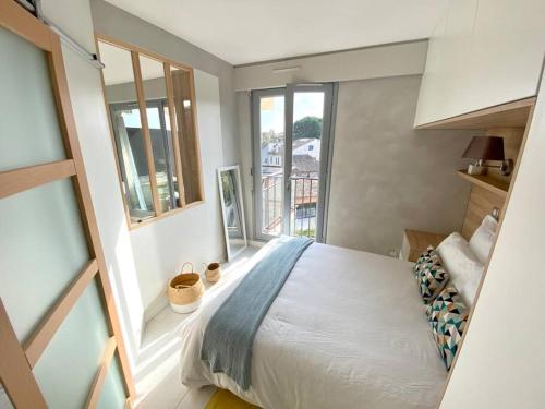 une chambre avec un lit et une grande fenêtre dans l'établissement Appt Standing StTropez terrasse Piscine Parking, à Saint-Tropez