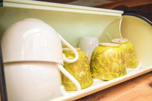 a shelf with yellow and white vases on it at 帝塚山忍者屋敷 in Osaka