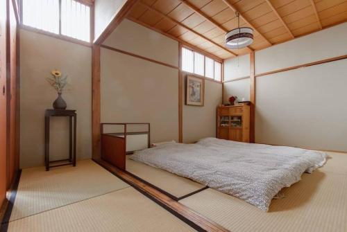 1 dormitorio con 1 cama en una habitación con ventanas en 帝塚山忍者屋敷 en Osaka