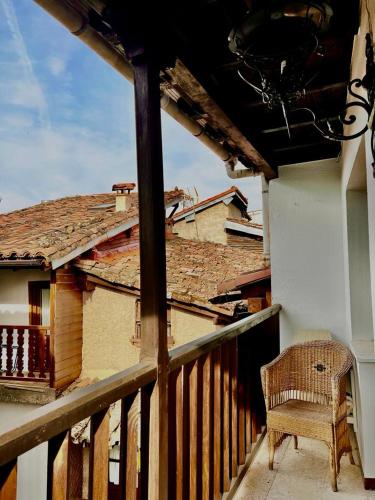 a chair sitting on a balcony of a house at Casa Rural "Calle Real" en La Vera in Villanueva de la Vera