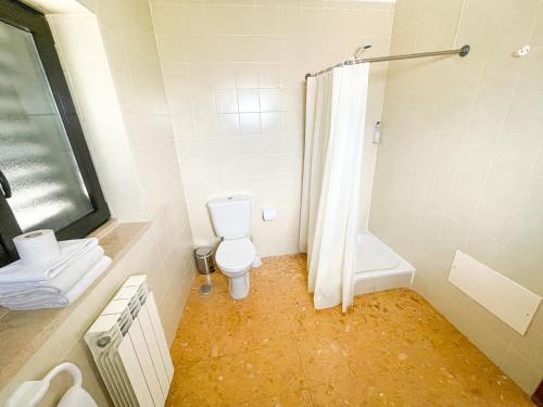 a white bathroom with a toilet and a shower at HI Areia Branca - Pousada de Juventude in Areia Branca
