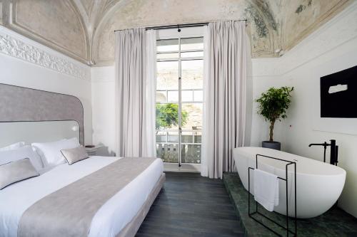 a bedroom with a bed and a bath tub and a window at Artemisia Domus - Giardino in Naples