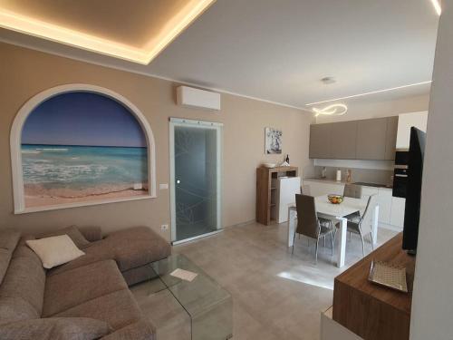 a living room with a couch and a table and a kitchen at Lecci al Mare in San Vincenzo