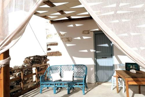 un banc bleu assis sur une terrasse couverte avec un escalier dans l'établissement Naxos Mountain Retreat - Tiny House Build on Rock, à Kóronos