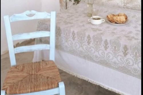 a table with a plate of bread and a chair at Naxos Mountain Retreat - Tiny House Build on Rock in Kóronos