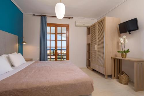 a bedroom with a large bed and a television at Vallia's Seaview Complex in Argasi