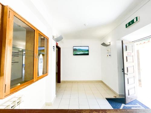 a hallway with a door and a tv on the wall at HI Areia Branca - Pousada de Juventude in Areia Branca