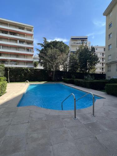 une grande piscine bleue dans un immeuble dans l'établissement Ambre d' Or apartment by Welcome to Cannes, à Cannes