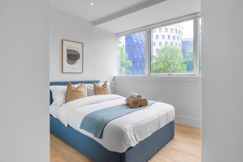 a bedroom with a large bed with a large window at Livestay-Modern Apartments Next To Wembley Stadium in London