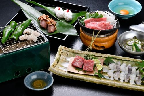 a table topped with different types of food on plates at Ryokan Sumiya Kihoan in Kameoka