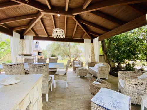 a patio with a table and chairs and a wooden ceiling at Villa Maria Beatrice in Quartu SantʼElena