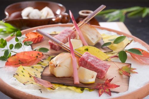 a plate of food with meat and chopsticks on it at Ryokan Sumiya Kihoan in Kameoka