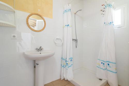 La salle de bains est pourvue d'un rideau de douche et d'un lavabo. dans l'établissement Ca Na Maria -Dorant-, à Son Serra de Marina