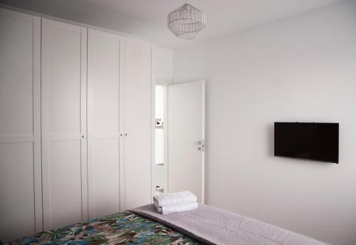 ein Schlafzimmer mit einem Bett und einem TV an der Wand in der Unterkunft Elis Apart in Oradea