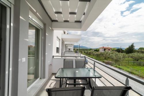 a balcony with a table and chairs and a view at Nefeli & Nefeli Luxury Residential Complexes in Ofrínion