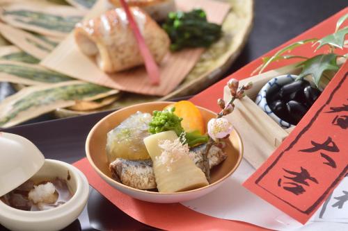 a table topped with bowls of food on a table at Ryokan Sumiya Kihoan in Kameoka