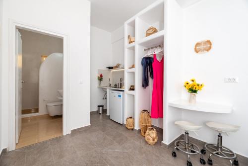 a bathroom with white walls and white shelves at Thallos Cave House and Apartments in Karterados