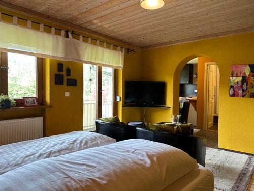 a bedroom with two beds and a flat screen tv at Maier Pension in Bayerisch Eisenstein
