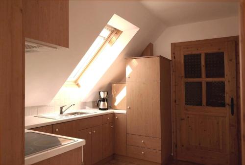 a kitchen with a window and a sink and a refrigerator at Ferienwohnungen Raczkowski in Birkfeld