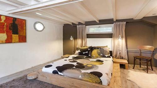 a bedroom with a large bed with a cow print on it at Studio in Woonboot + privébadkamer en -tuinterras in Utrecht