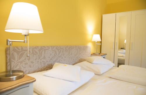 a hotel room with two beds with a lamp on it at Hotel Landsitz Pichlschloss in Neumarkt in Steiermark