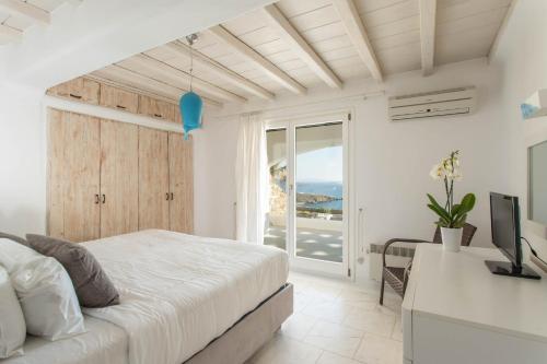 una camera con letto e scrivania con TV di Villa Alitis by Mykonos Rocks a Mykonos Città