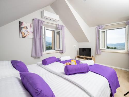 2 camas con almohadas moradas en un dormitorio con ventanas en Villa Starry Sky ,Hvar en Jelsa