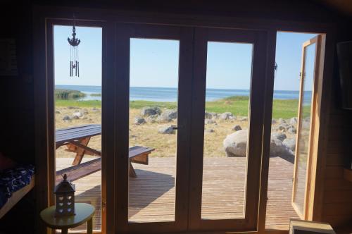 una puerta a una terraza con vistas al océano en Manija saare süda - Manija island, en Pärnu