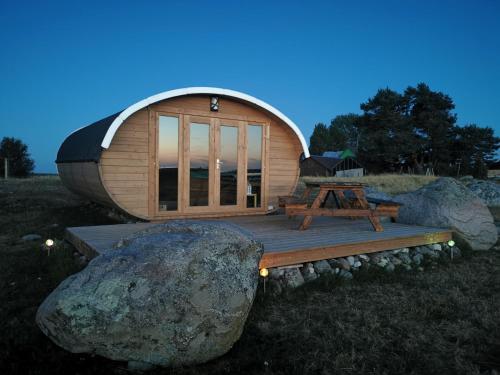 Cabaña de madera pequeña con una roca grande en Manija saare süda - Manija island, en Pärnu