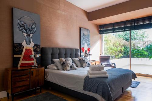 um quarto com uma cama e uma grande janela em House of Joy em Estoril