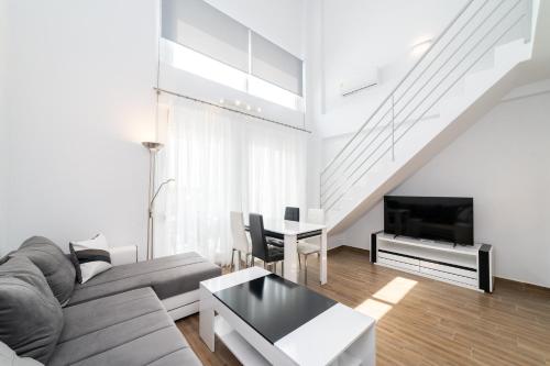 a living room with a couch and a tv and a table at Nefeli & Nefeli Luxury Residential Complexes in Ofrínion